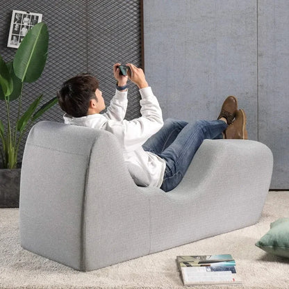 Comfortable gray zero gravity chaise lounger in modern living room with person relaxing