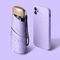 Compact folding sun umbrella with ultraviolet protection, alongside a sleek white smartphone on vibrant purple background.