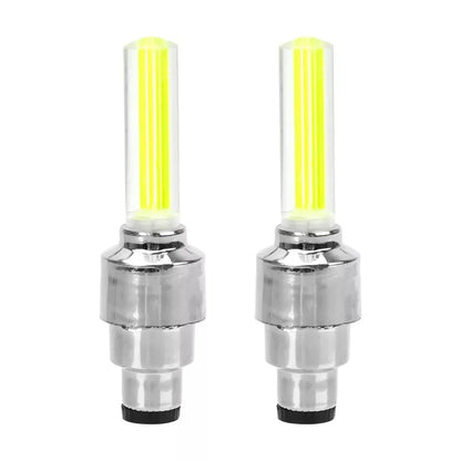 Decorative chrome tire valve caps with yellow LED lights for cars, motorcycles, or bicycles. Cycling warning flashlight lamps attached to the valve stems.